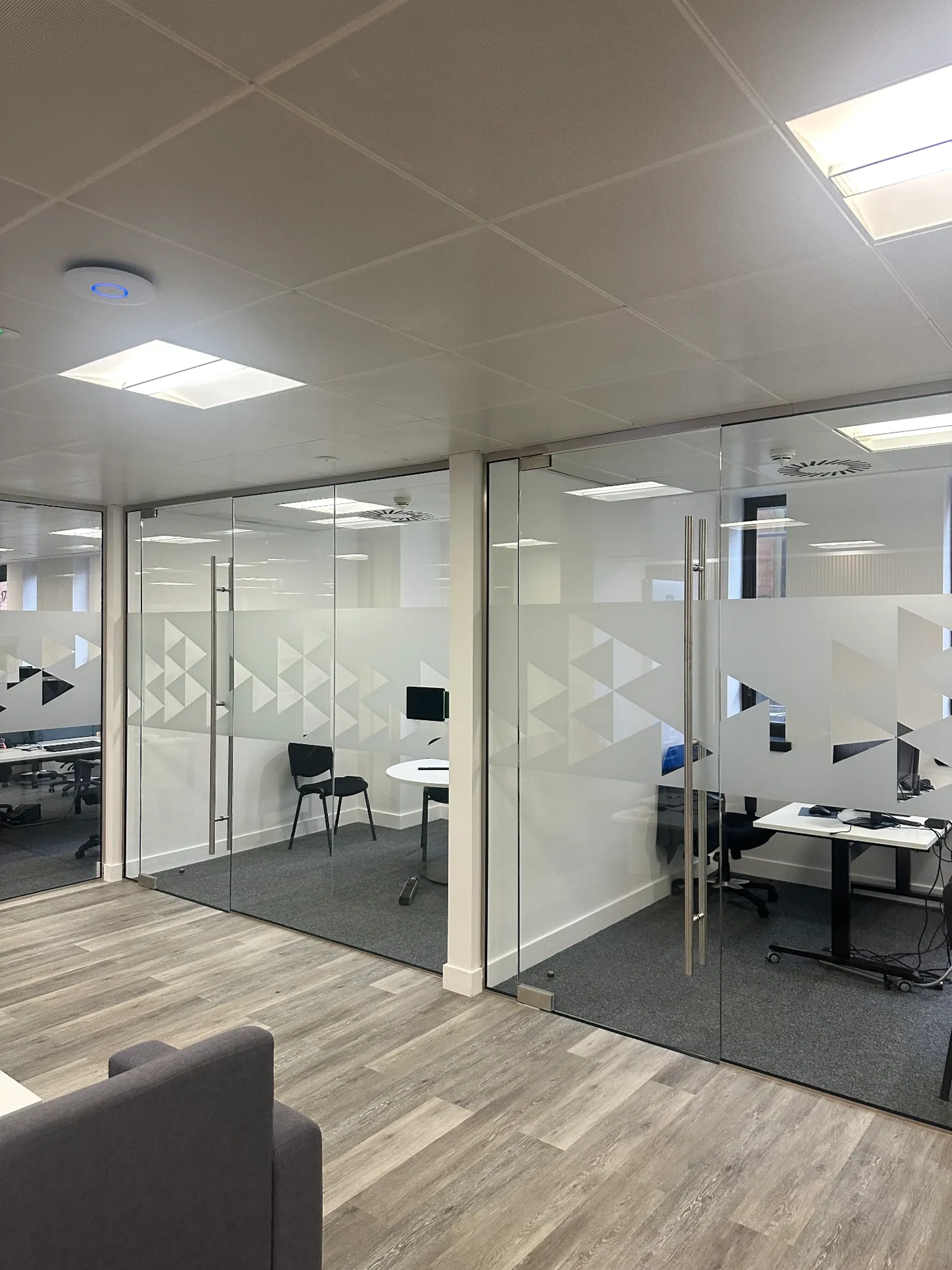 Triangle-pattern frosted manifestation film across frameless glass office partitions and doors